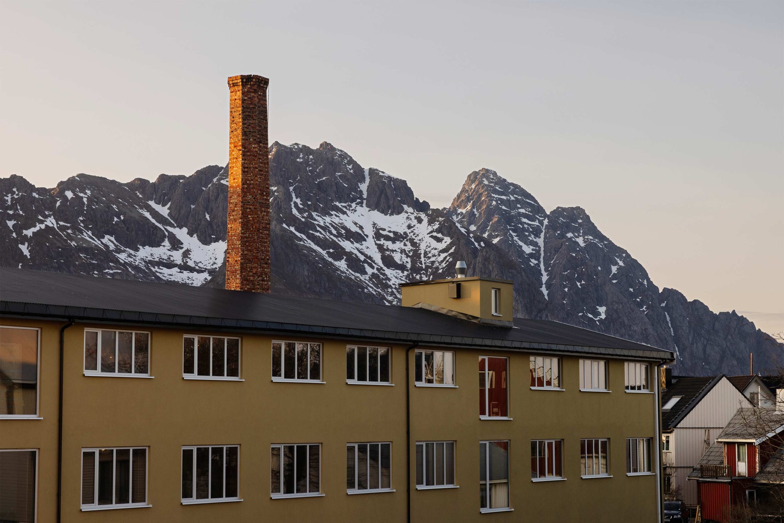 The newly insulated building surrounded by the mountains of Lofoten.