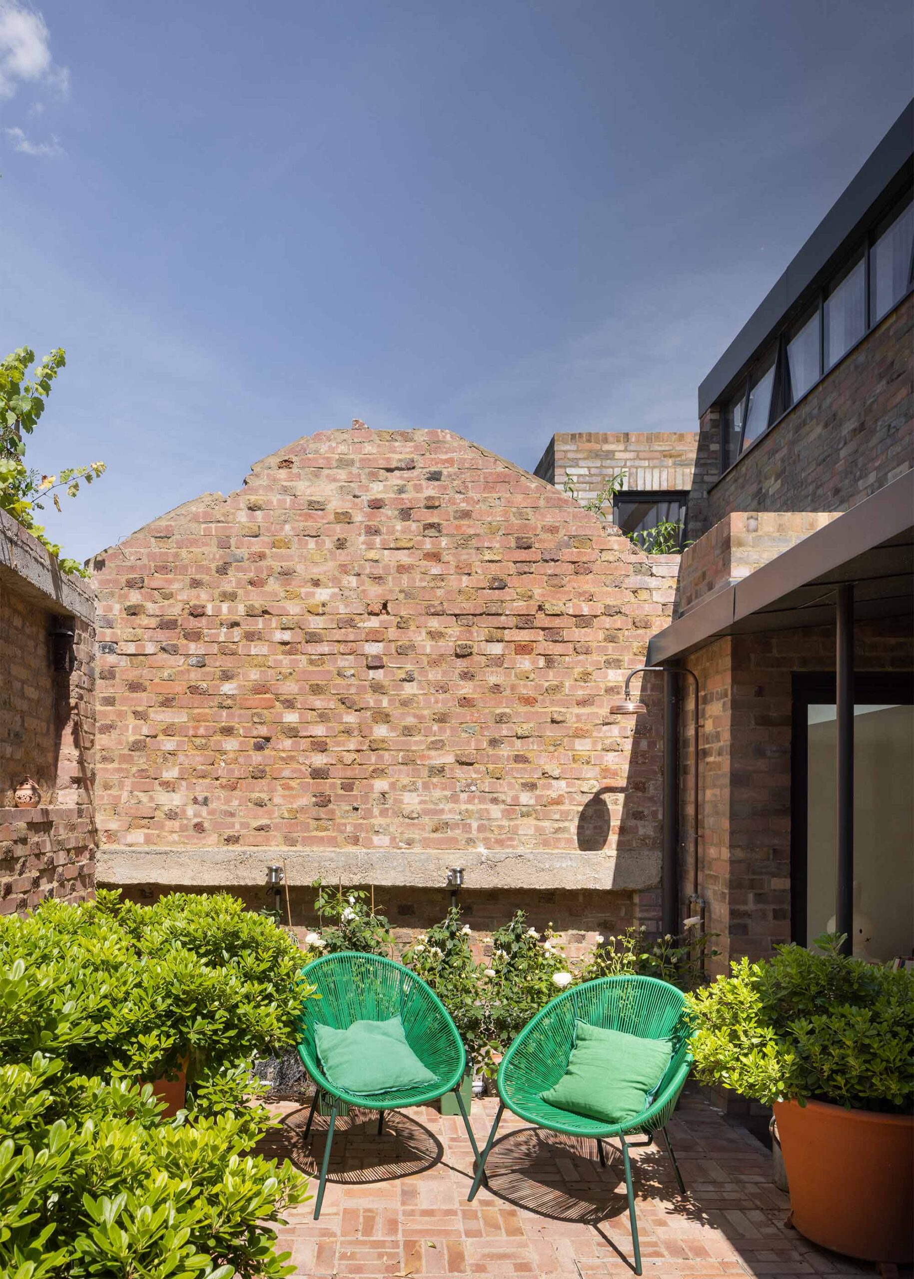 The rear courtyard embraced by existing brick gables. 